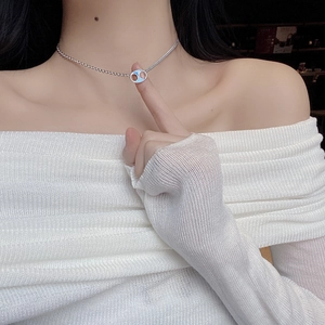 Detail of silver pig nose necklace with blue enamel pendant on model's neck