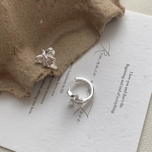 Detail van S925 sterling zilveren strikoorbellen op een elegante vintage achtergrond