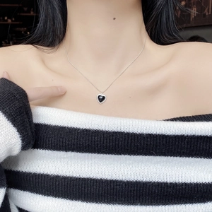 Detail of S925 sterling silver black onyx heart pendant necklace with rhinestones on model