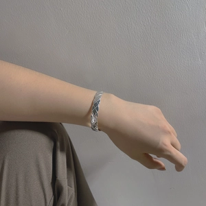 Macro shot of silver 925 cuff bracelet featuring a quilted texture and polished finish