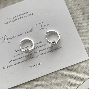 Detailweergave van de S925 sterling zilveren strikknoop oorringen op een vintage kaart