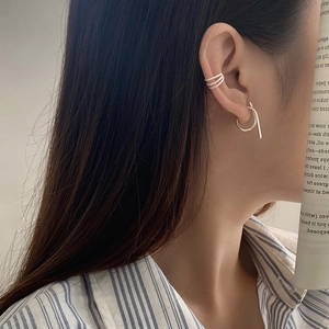 Detail view of S925 sterling silver twist ear cuff and geometric drop earring on model