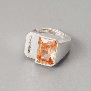 Macro detail of S925 sterling silver ring with orange zircon and side engraving
