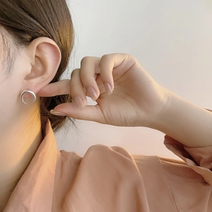 Close-up of minimalist S925 sterling silver crescent moon stud earring on model