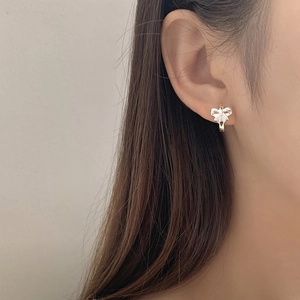Minimalistische S925 sterling zilveren strik oorbellen gedragen door een model