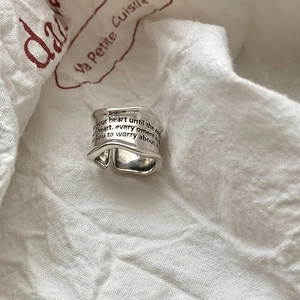 Macro shot of S925 sterling silver wide ring with engraved quotes on wave edge