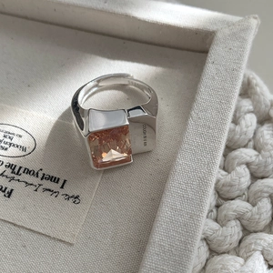 Macro shot of 925 silver ring featuring rectangle orange zircon and brand engraving