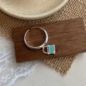 Macro view of S925 sterling silver ring with blue enamel lock pendant on wood