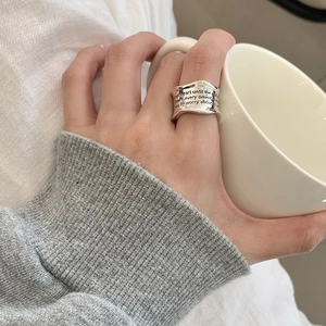Detailed view of wide 925 sterling silver ring with engraved lettering on model hand