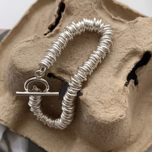 Macro detail of 925 sterling silver layered coil bracelet with classic OT toggle clasp