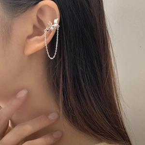 Elegant S925 silver bow ear cuff with long tassel chain shown on model's ear