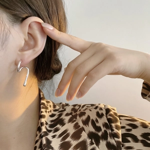 Detail view of 925 sterling silver S-curve earrings with a minimalist wavy design
