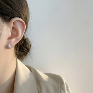 Nahaufnahme unregelmäßiger Lavastrukturen aus 925er Sterlingsilber am Ohr des Models