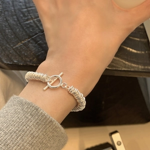 Detailed close-up of S925 silver spiral coil bracelet featuring a stylish OT buckle closure