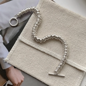 Detail of silver S925 interlocking circle bracelet with OT toggle clasp on canvas background