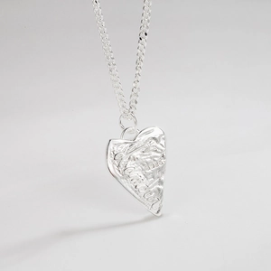 Macro view of S925 sterling silver heart necklace with rock texture and Amour engraving