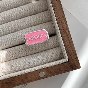 Detailansicht des rosa Emaille-Rings mit FEDERICA-Schriftzug und silberner Metalleinfassung
