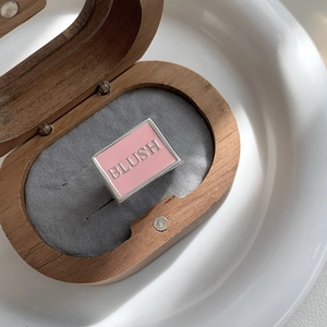Close-up of pink enamel wide silver ring with BLUSH engraving in a jewelry box