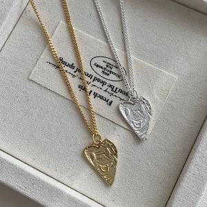 Close-up of gold and silver S925 sterling silver heart necklaces with smiley face pattern