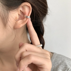 Close-up of minimalist 925 silver triple-line ear cuff and twisted rope ring on model