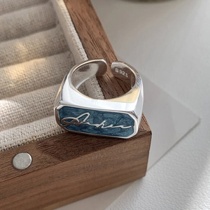 Macro shot of S925 sterling silver ring with blue enamel rectangle and script design