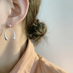 Boucles d'oreilles pendantes en U en argent sterling S925 portées par un mannequin de profil