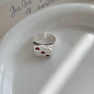 Detailed macro view of S925 sterling silver ring with three red enamel hearts and arrow symbols