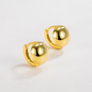 Detailed macro view of high-polished gold spherical stud earrings with clasp closure