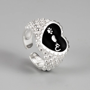 Macro detail of S925 sterling silver ring featuring a black enamel heart with paw print