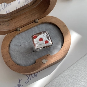 Detailed macro view of 925 sterling silver square ring with red heart enamel in wood box