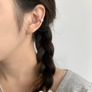 Close-up of a triple-line silver ear cuff worn by a model, showing sleek minimalist design