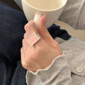 Detailed shot of a 925 silver wide ring with pink enamel face and BLUSH engraving