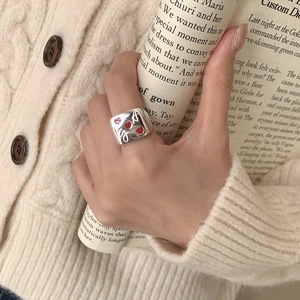 Detail of 925 silver ring featuring three red enamel hearts and engraved G letter