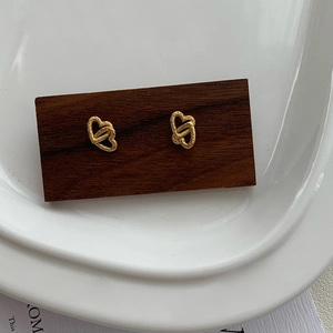 Macro view of gold S925 sterling silver heart studs with textured hammered surface