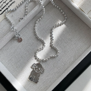 Detailed macro of S925 sterling silver teddy dog pendant showing the material hallmark tag