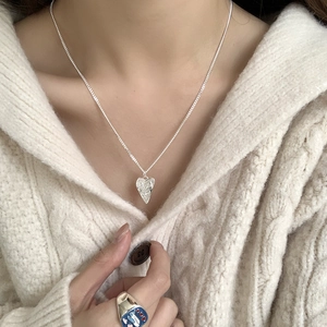 Minimalist S925 sterling silver heart necklace and bird ring on white knit sweater
