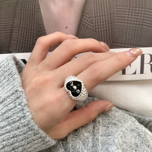 Detail of 925 sterling silver ring with black enamel heart and silver puppy paw prints