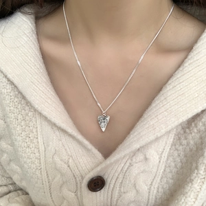 Detail of S925 sterling silver heart necklace with irregular hammered texture on pendant