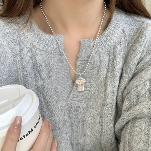 S925 sterling silver teddy dog pendant on bead chain worn by model in lifestyle setting