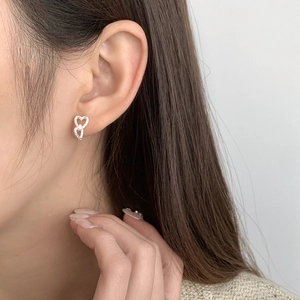 Close-up of S925 silver double heart stud earrings with cubic zirconia on female model