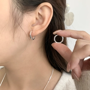 Gros plan détaillé des boucles d'oreilles géométriques en argent sterling 925 sur l'oreille