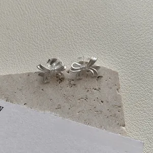 Vue détaillée des boucles d'oreilles nœud en argent S925 avec texture mate brossée