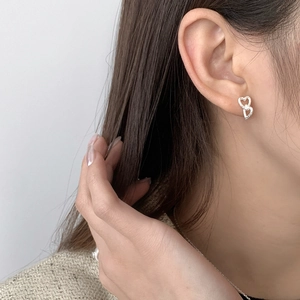 Macro detail of S925 sterling silver interlocking heart earrings with cubic zirconia stones