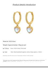 Macro detail of S925 silver heart moonstone earrings with 18k gold twist hoop design
