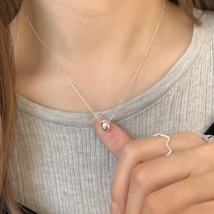 Minimalist S925 sterling silver necklace with a tiny pavé bean pendant on a female model