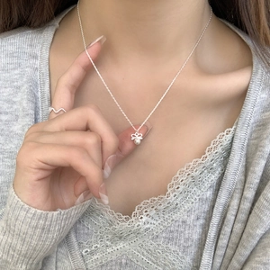 Elegant S925 sterling silver necklace with bow pendant and matching pearl ring on a model
