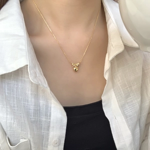 S925 sterling silver gold heart and bow pendant necklace shown on a model's neck