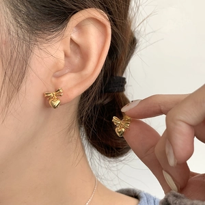 S925 silver ballet-style gold bow heart stud earrings shown on model ear