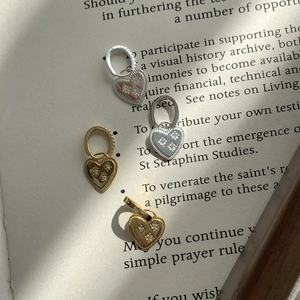Retro S925 silver heart earrings with star zircon stones on vintage book page background