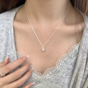 Close-up of S925 sterling silver bow necklace with white pearl on a fashion model